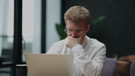 frustrated-and-annoyed-man-with-glasses-is-reading-news-in-internet-looking-at-display-of-laptop